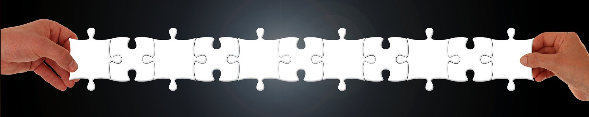 two hands holding a chain of puzzle pieces